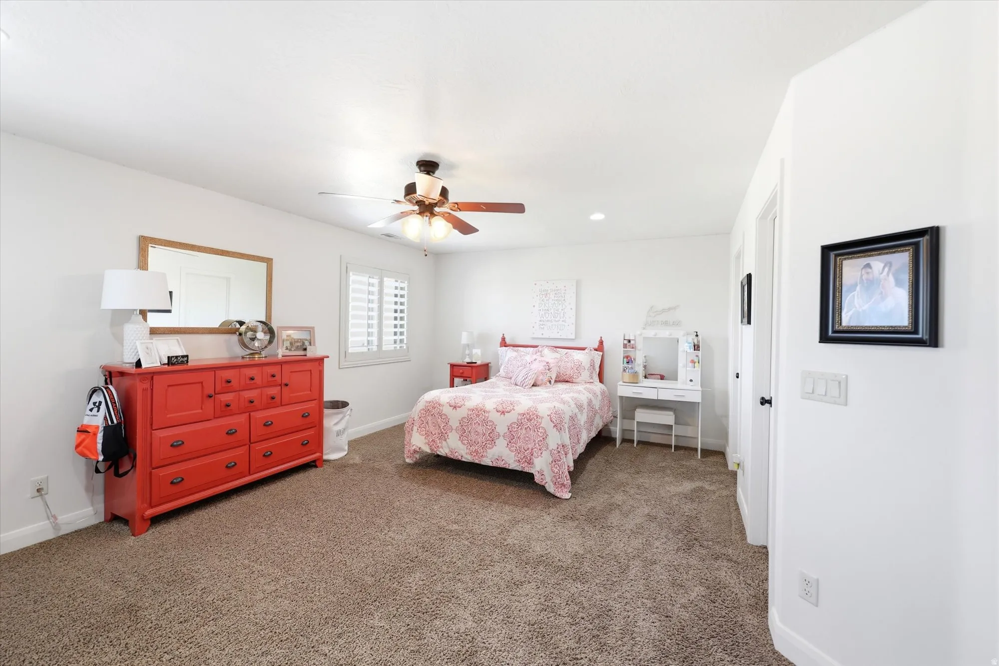 Second Primary Carpeted room featuring a ceiling fan with integrated lighting, a window with white plantation shutters, and a white door frame