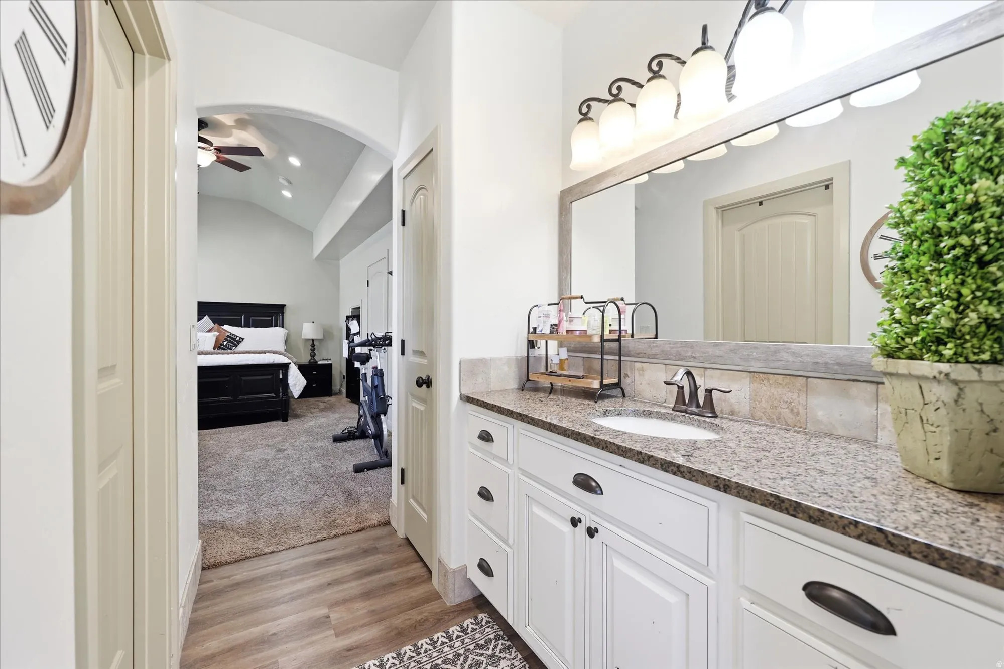 PRIMARY Bathroom vanity featuring a granite countertop, undermount sink, and a framed mirror with a four-bulb light fixture