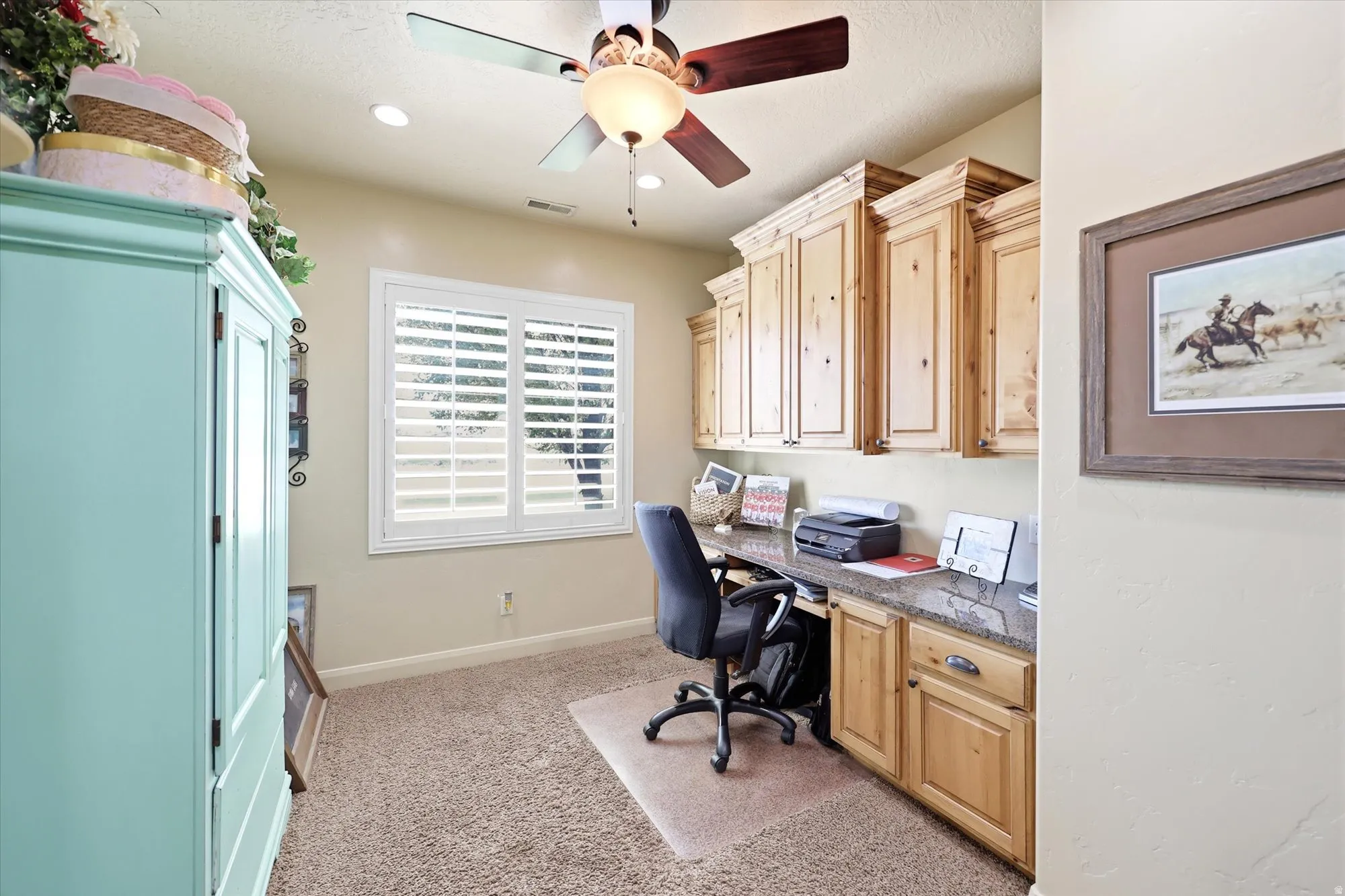 Built-in cabinetry with natural wood finish, a stone-finish countertop, and recessed lighting
