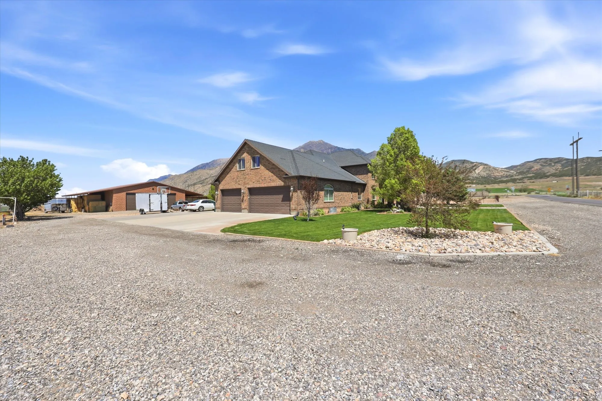 Brick exterior residence featuring a two-car garage, dormer windows, and established landscaping
