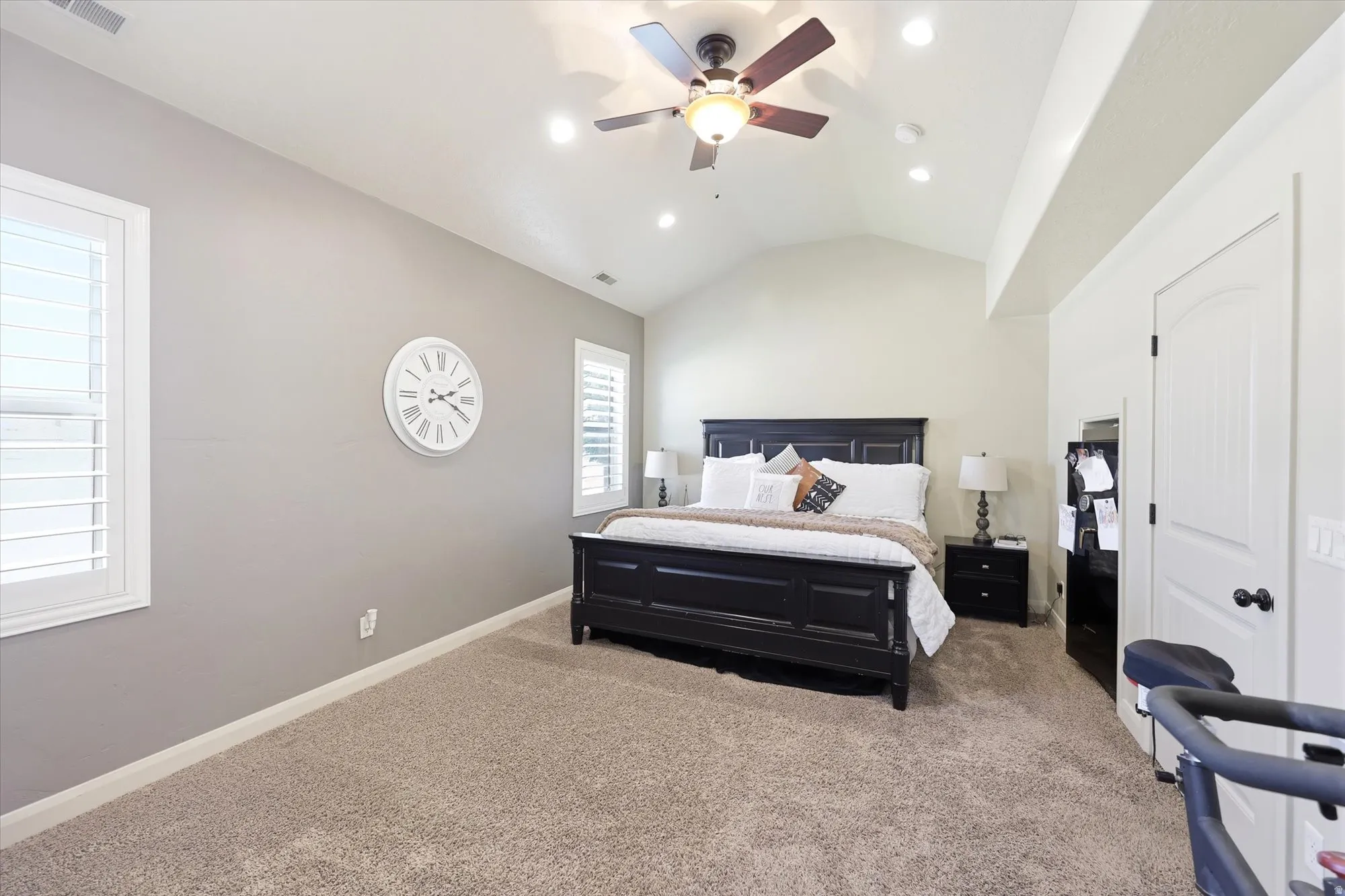 PRIMARY Spacious room featuring vaulted ceilings, recessed lighting, a ceiling fan with light fixture, plantation shutters, and soft carpet flooring