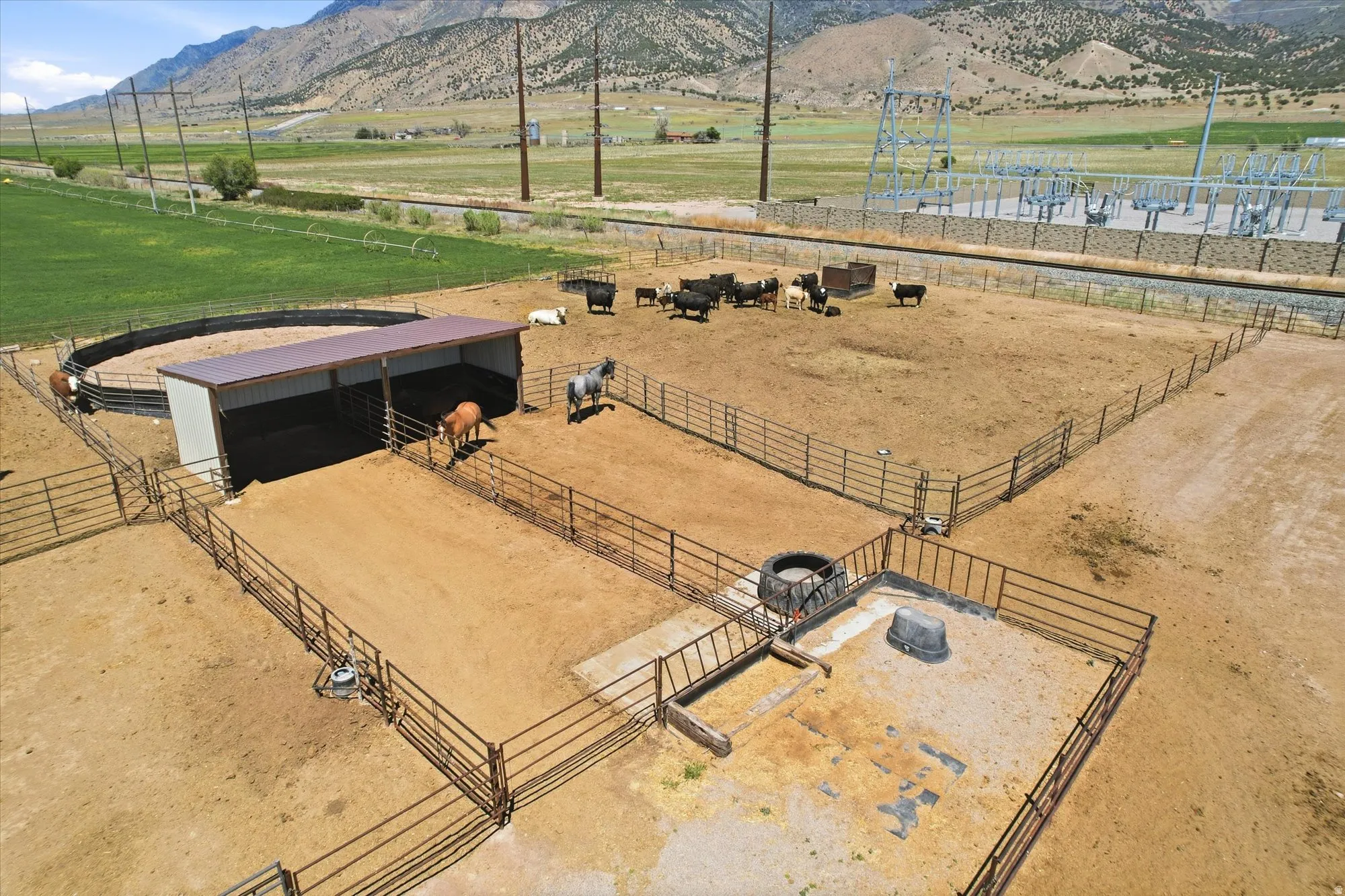 Expansive fenced corrals and pens featuring a covered shelter and round pen
