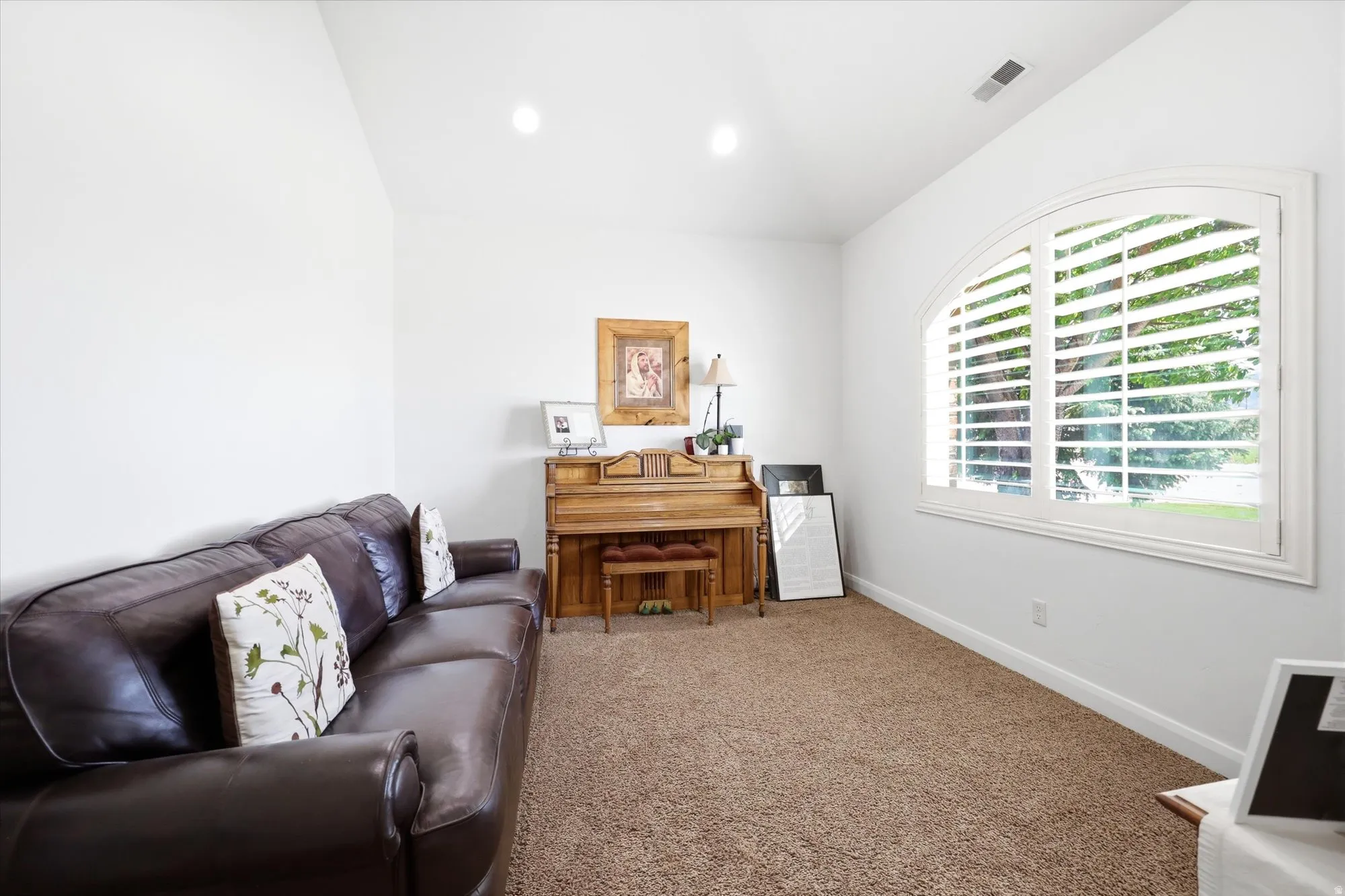 Room featuring a vaulted ceiling and neutral-toned carpeting