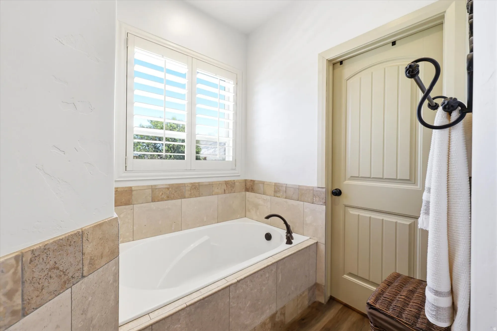 PRIMARY Soaking tub with a bronze-finish faucet, surrounded by natural stone tile