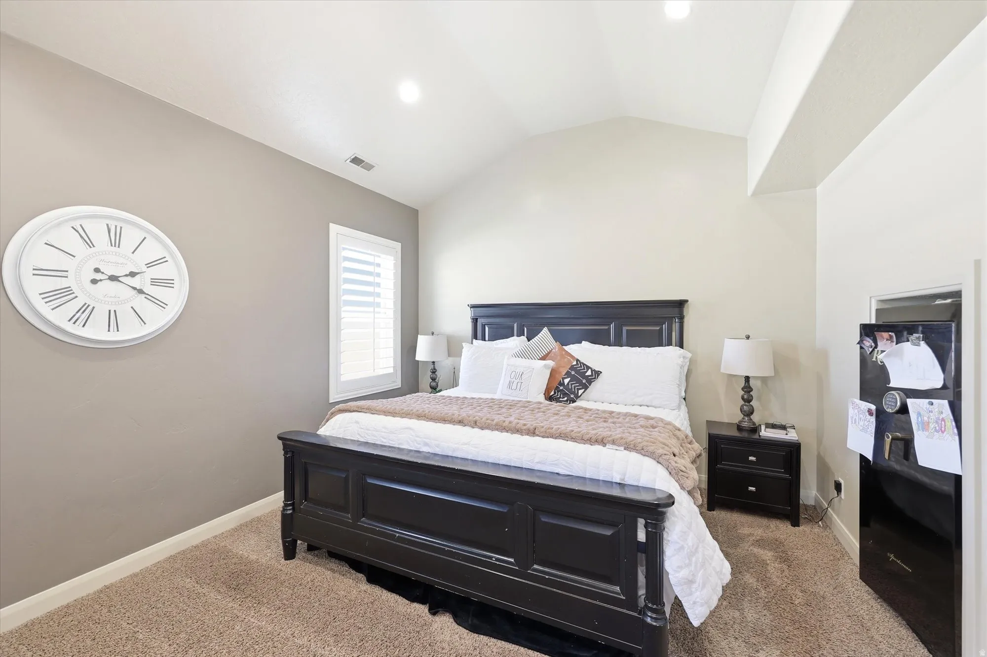 PRIMARY Vaulted ceilings enhance this room, featuring recessed lighting and a window with white louvered shutters