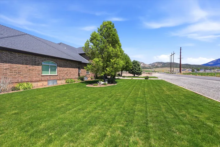 Expansive green lawn with established trees and surrounding mountain scenery