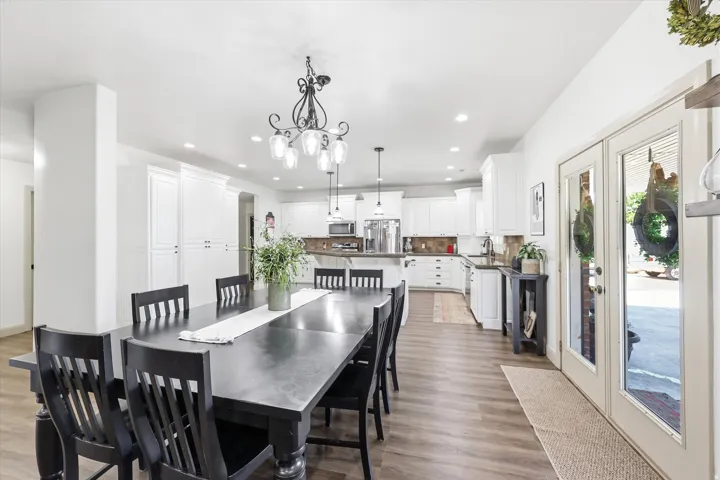 Open concept living space featuring wood-finish flooring, white cabinetry, and recessed lighting