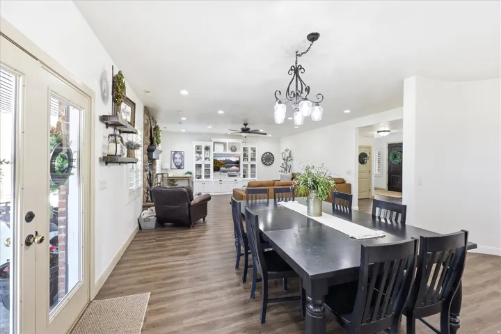 Open-concept living space featuring wood-finish flooring, recessed lighting, and a decorative chandelier