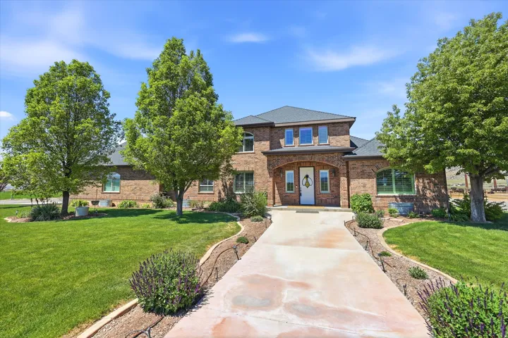 Brick exterior residence featuring a covered entry, arched window above the front door, and a concrete driveway