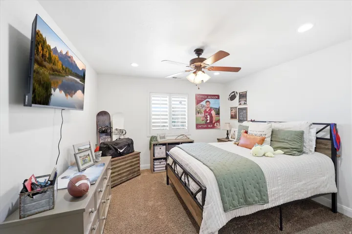 Bedroom featuring warm beige carpeting, recessed lighting, and a ceiling fan with integrated light fixture