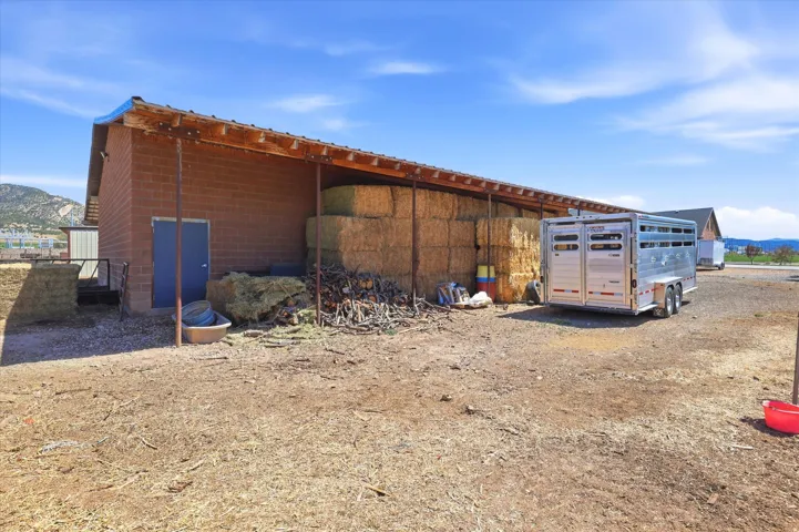 Agricultural structure with brick-finish exterior and an attached wood-frame overhang