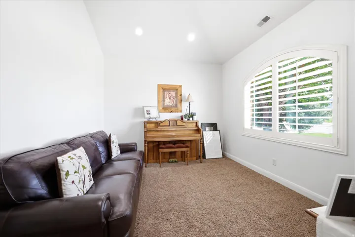 Room featuring a vaulted ceiling and neutral-toned carpeting