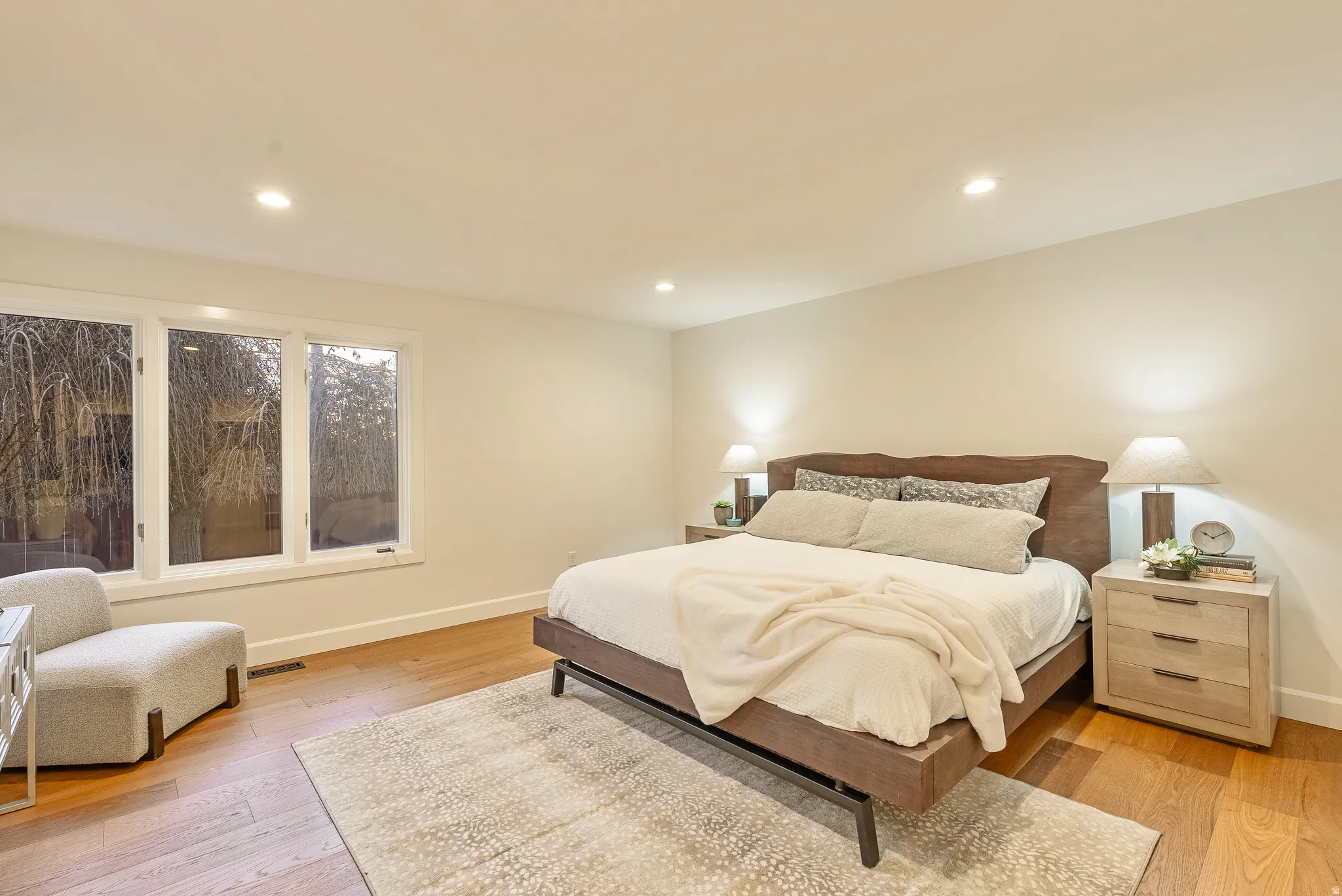 Spacious room featuring hardwood flooring and recessed lighting