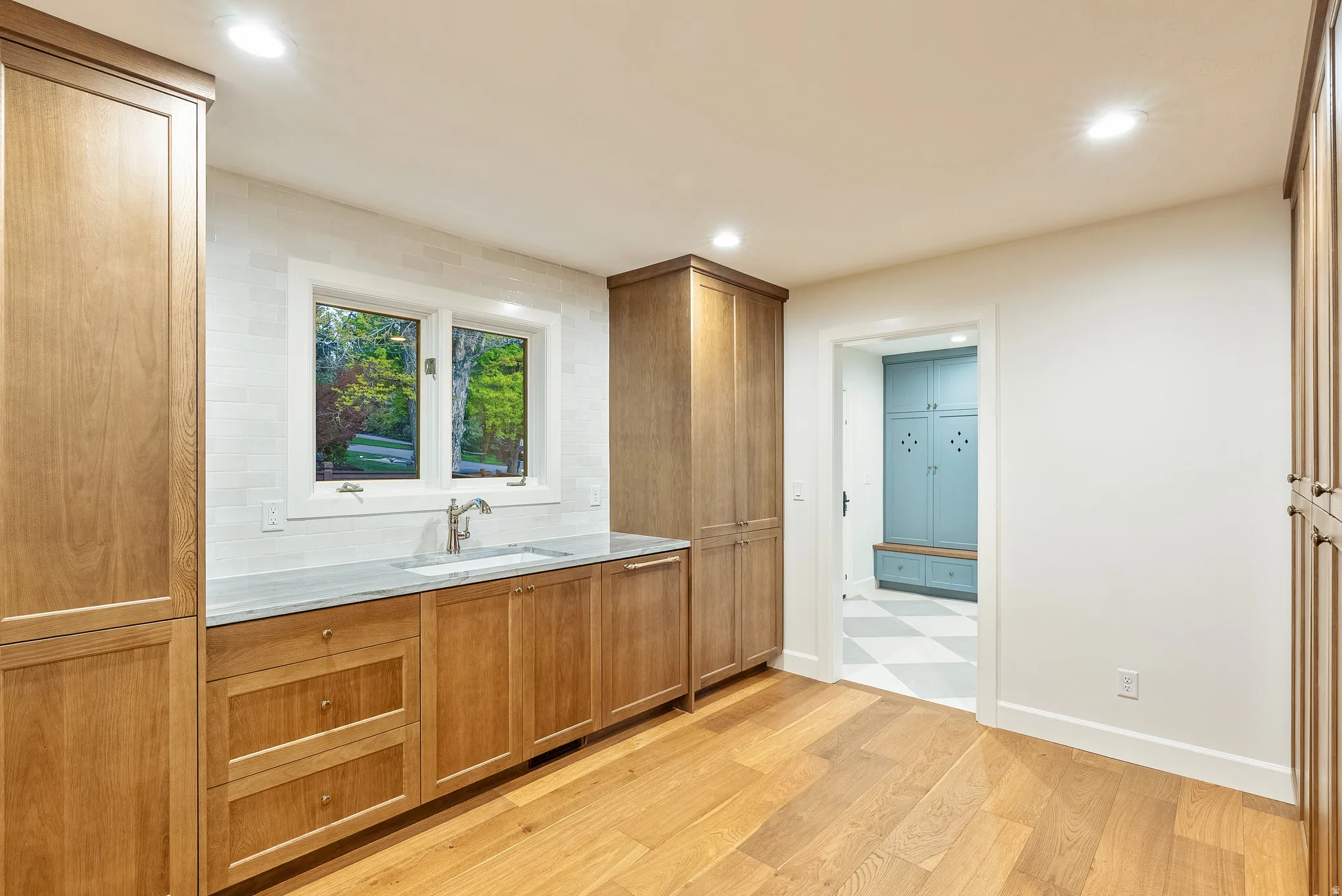 Light wood-finish cabinetry with silver-tone hardware and light stone countertops