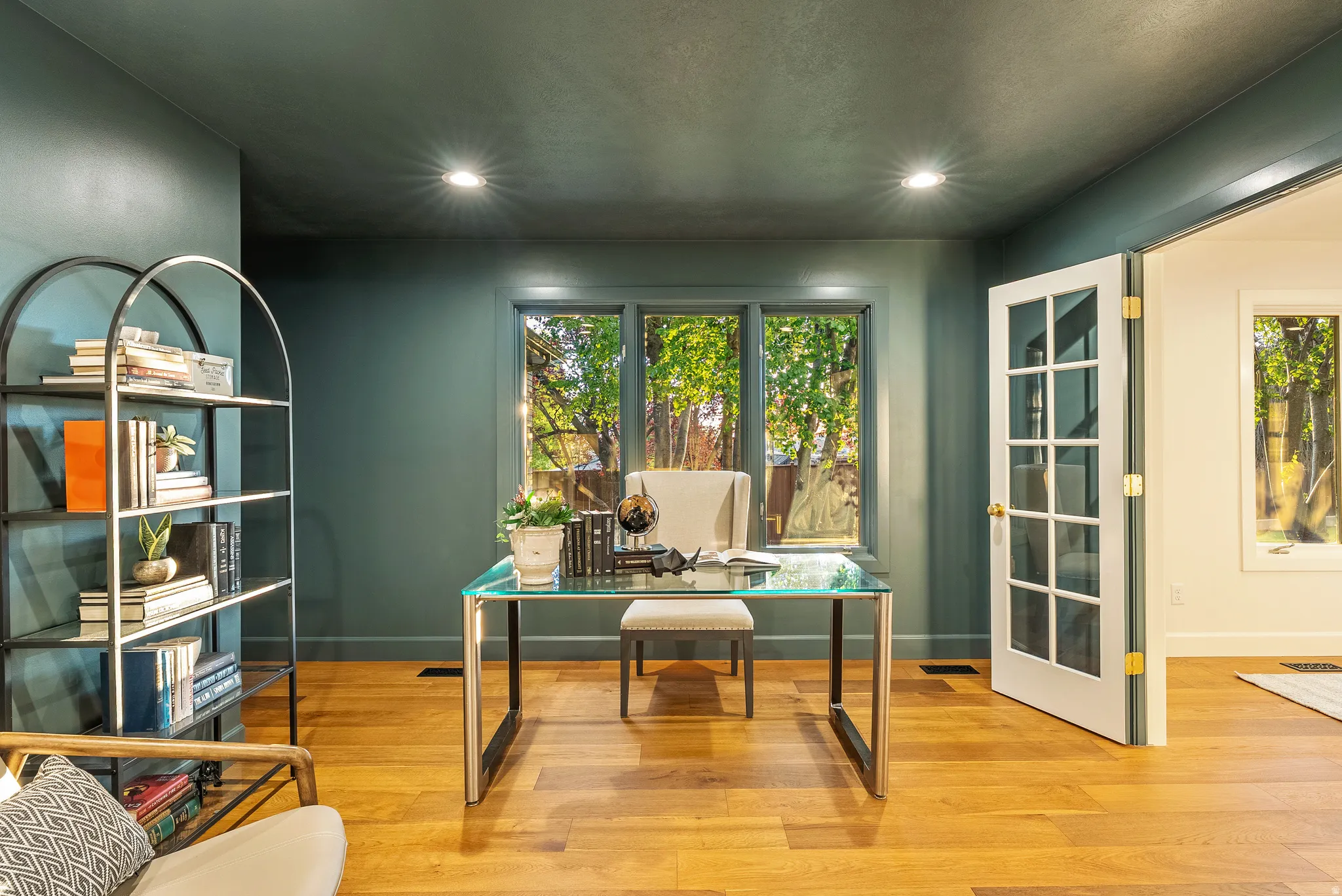 Private room featuring wood-finish flooring, recessed lighting, and a three-pane window