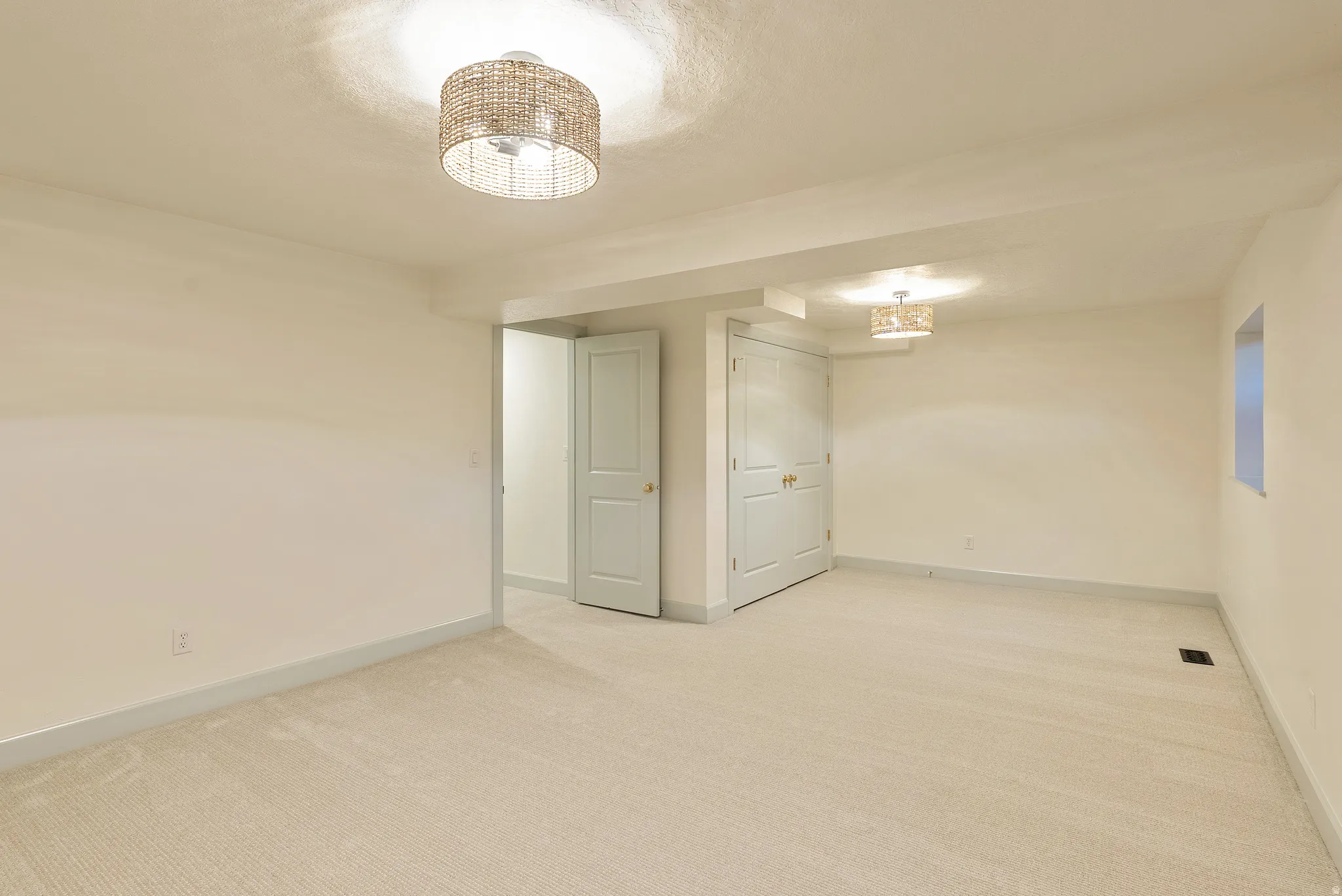Spacious room featuring neutral carpeting and light-toned walls