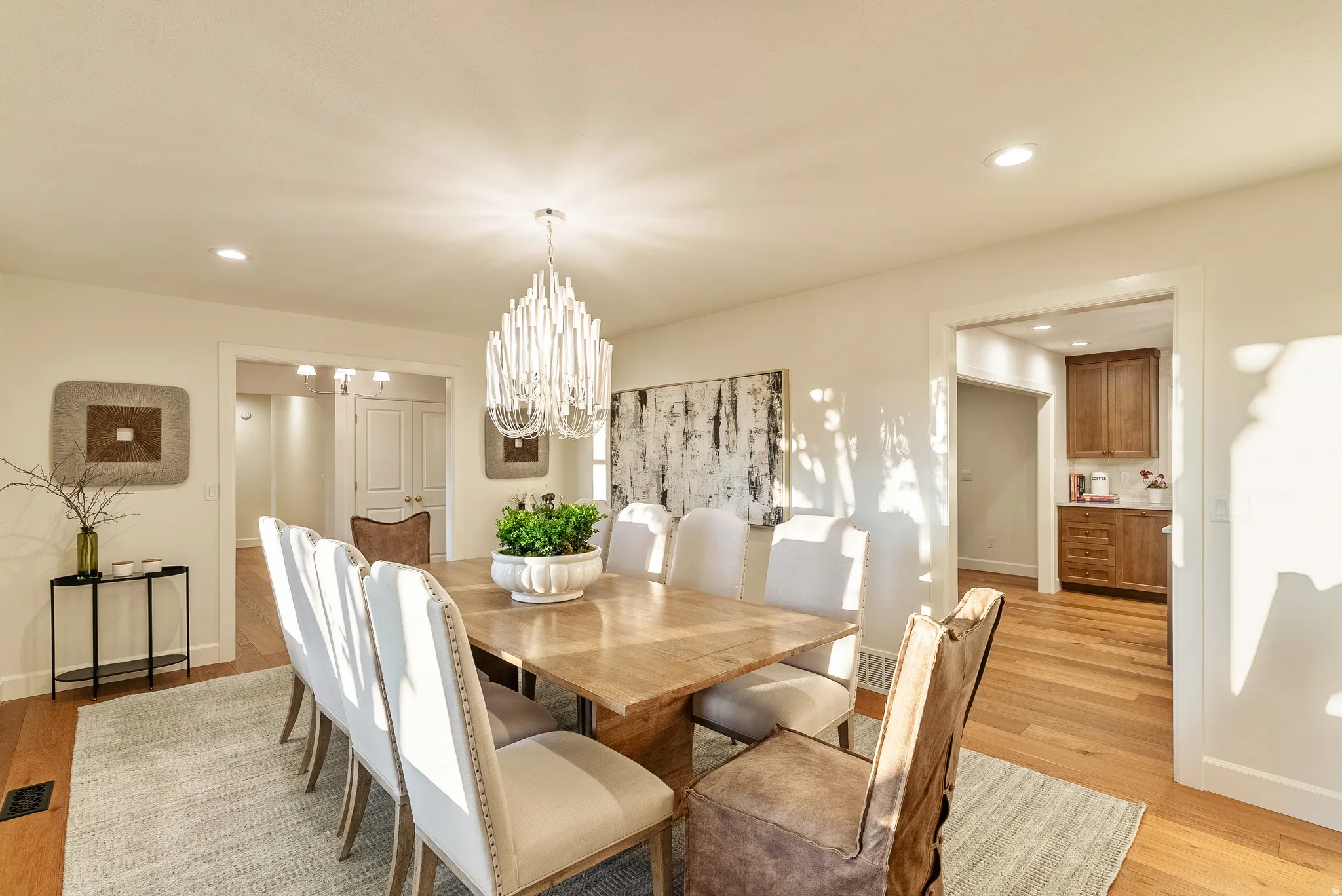 Dining area featuring wood-finish flooring, recessed lighting, and a prominent chandelier