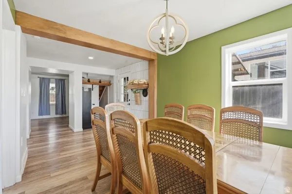 Dining area featuring a decorative chandelier, a window with natural light, and wood-finish flooring