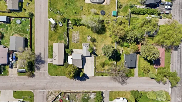 Aerial perspective showcasing a residential property with a central dwelling, a detached structure, and extensive green space