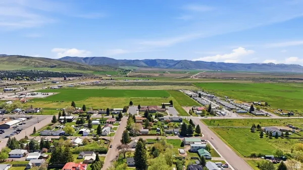Expansive mountain range backdrop framing a residential area with green fields