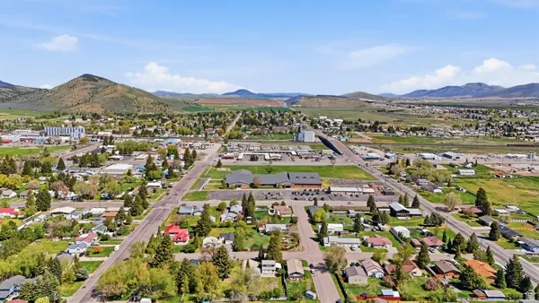 Expansive aerial perspective showcasing a community nestled within a valley, framed by distant mountains