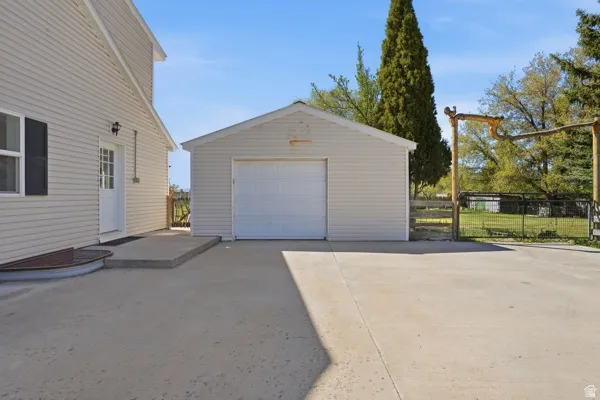 Detached garage with a white overhead door and light-colored siding