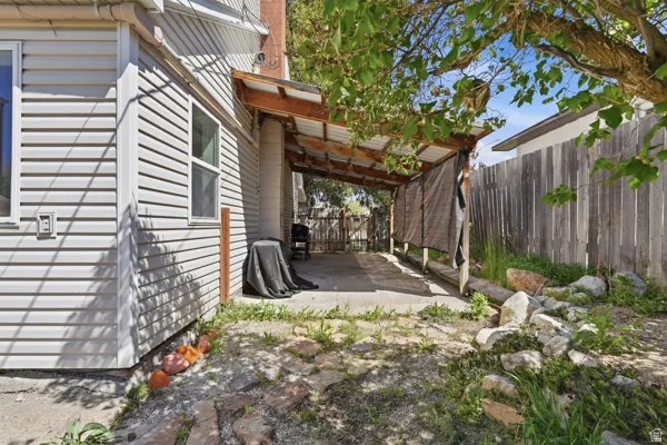 Rear patio featuring a covered area with a wood frame and translucent roof panels