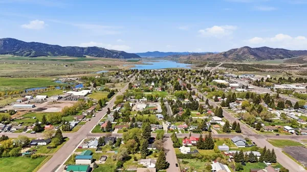 Aerial perspective showcasing a community layout with residential and commercial areas, surrounded by natural landscapes