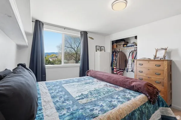 Room featuring a large window, built-in shelving, and an open closet