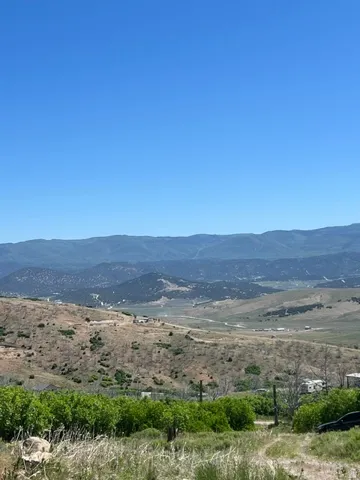 Expansive landscape featuring distant mountains and rolling hills with varied vegetation