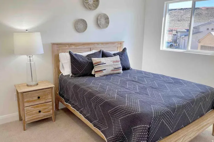 Bedroom featuring light wood-finish flooring, a window offering natural light, and neutral wall paint