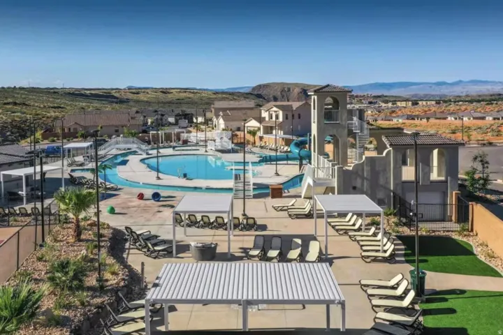 Expansive community pool area featuring a lazy river, water slides, and a multi-level activity tower