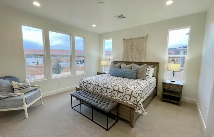 Carpeted room featuring multiple tall windows and recessed lighting
