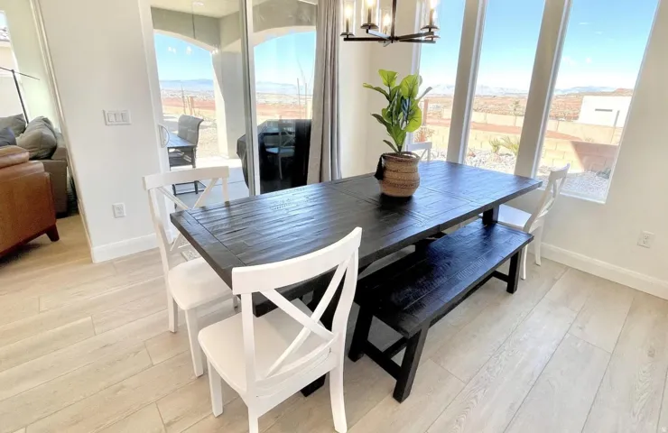 Dining area featuring light wood-finish flooring, a dark wood dining table, and a contemporary linear chandelier