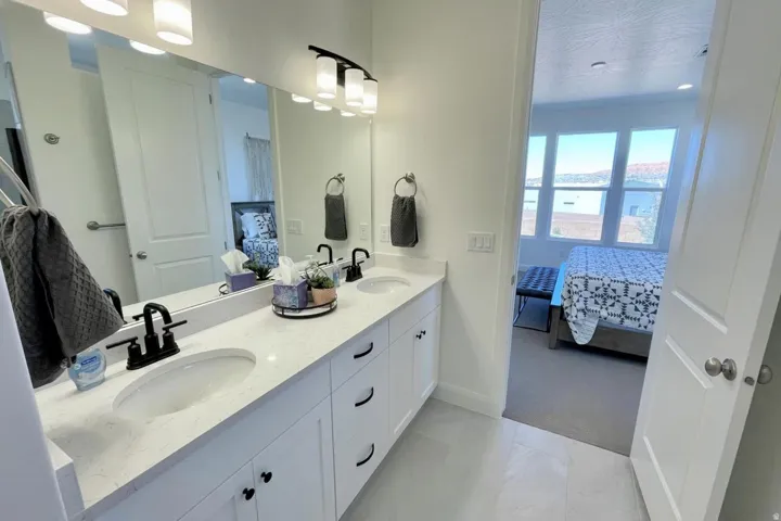 Dual vanity featuring undermount sinks, stone-finish countertop, and matte black fixtures