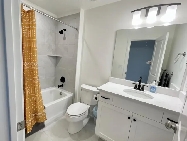 Bathroom featuring a single vanity with white cabinetry and a white countertop, an undermount sink with a matte black faucet, and a large wall-mounted mirror
