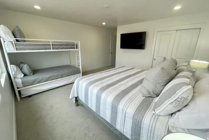 Carpeted room featuring recessed lighting, a mounted flat-screen, and a built-in closet with sliding doors
