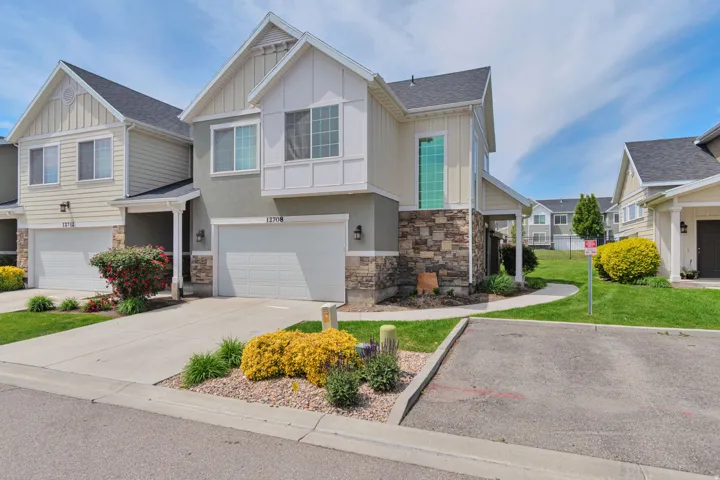 Townhome exterior featuring a 2 car garage next to visitor parking