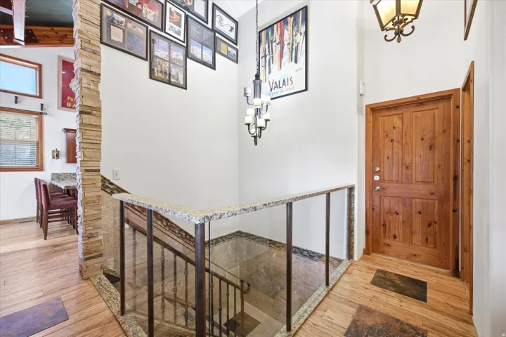 Foyer featuring a solid wood door, wood-finish flooring, and a wrought iron chandelier
