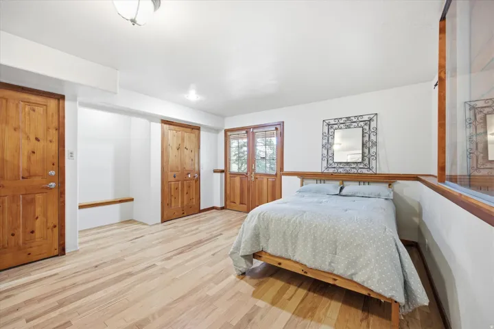 Spacious room featuring wood-finish flooring, white walls.