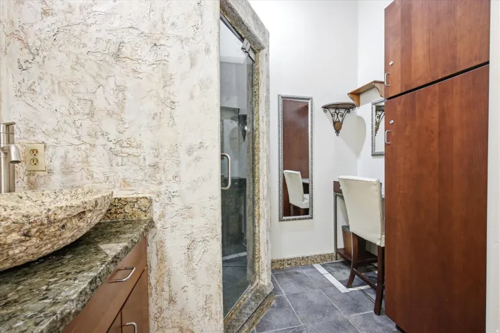 Granite vessel sink and countertop with textured wall finish