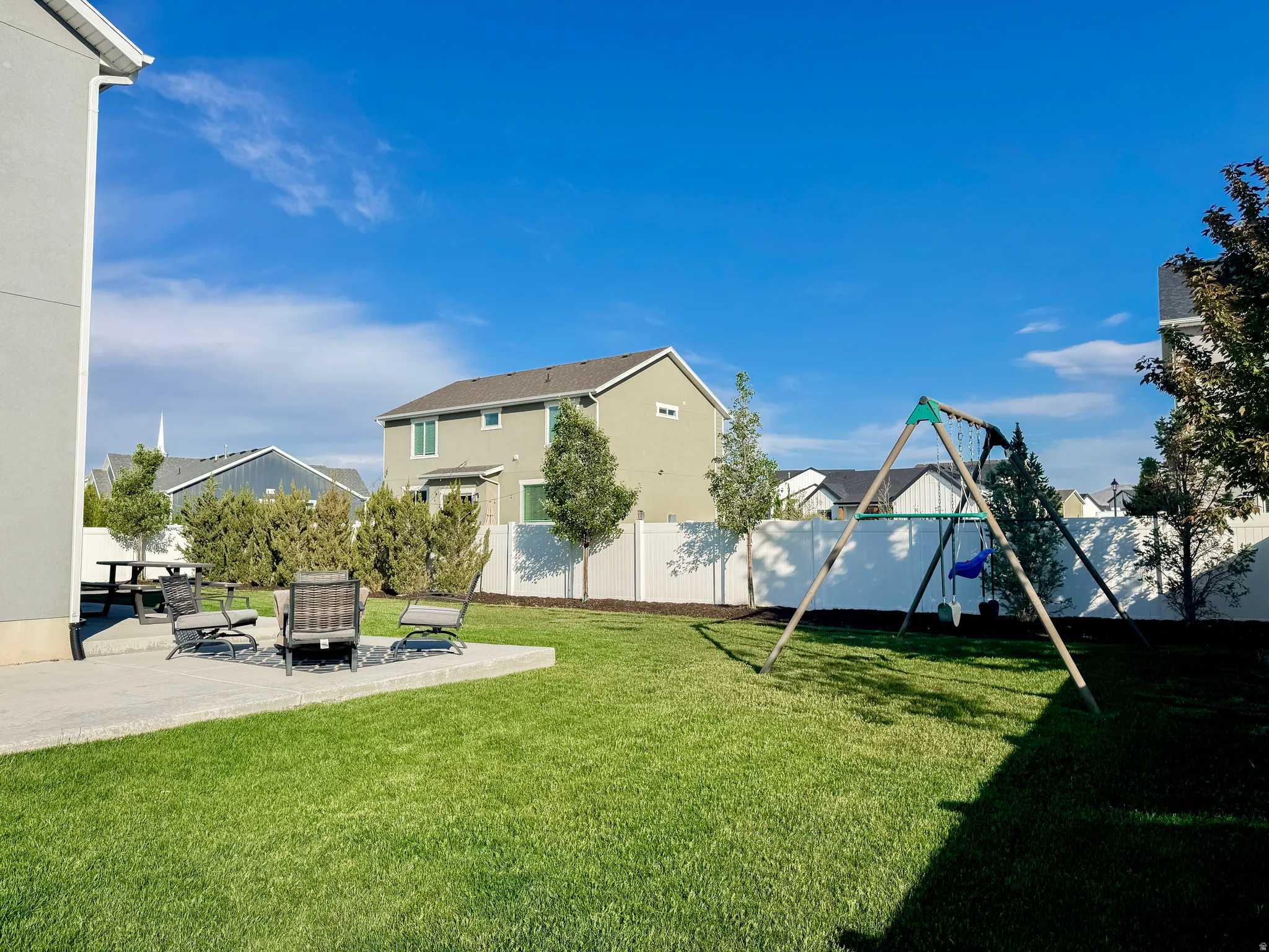 Expansive green lawn with a concrete patio