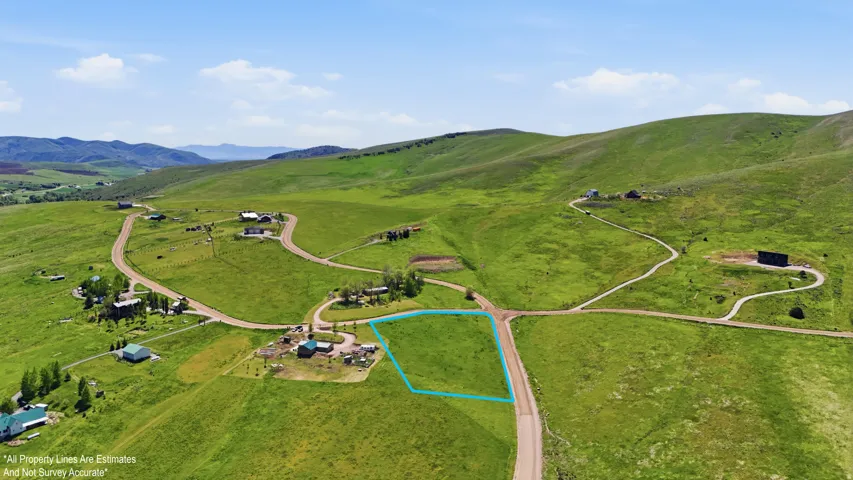 Expansive green terrain with scattered residential structures-boundary lines are for visual only