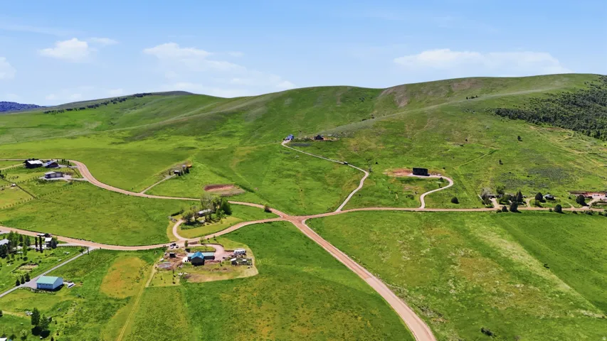 Rolling green hills with scattered residential structures