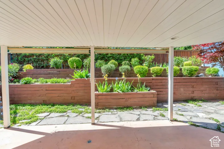Tiered wood retaining walls featuring established plantings