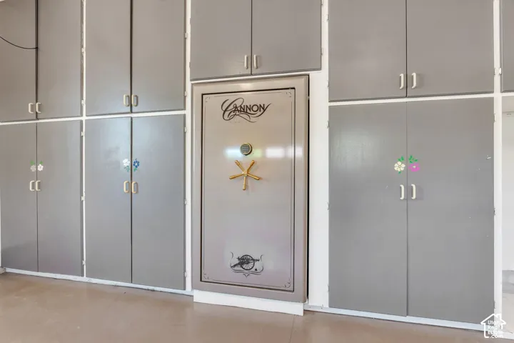 Integrated safe surrounded by extensive gray cabinetry with silver-tone hardware
