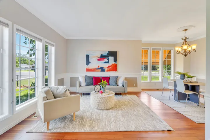 Open-concept living space featuring wood-finish flooring, white crown molding, and wainscoting
