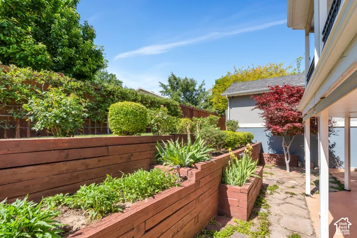 Terraced garden beds featuring wood retaining walls and established plantings