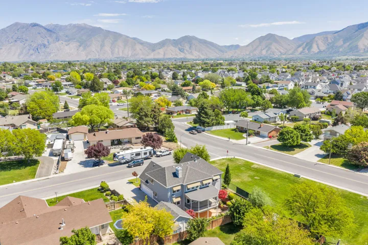 Suburban neighborhood with mature trees and mountain backdrop