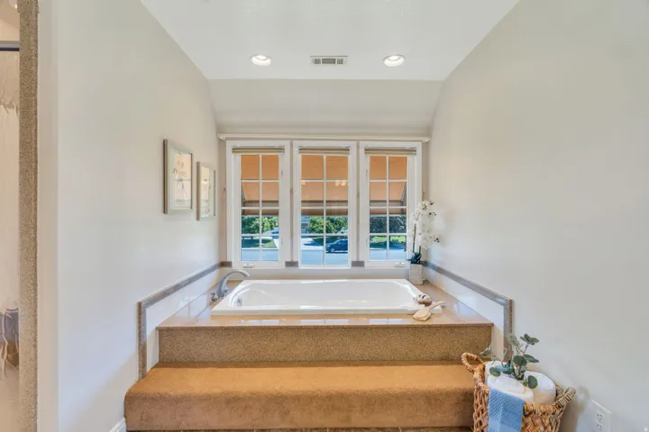 Built-in soaking tub with surrounding tiled and carpeted platform